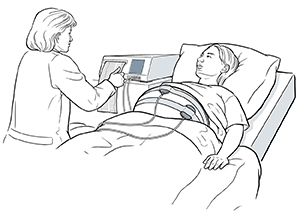 Embarazada recostada sobre una camilla, con correas alrededor del abdomen.